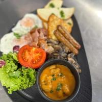 un piatto di cibo con un piatto di cibo con uova e verdure di Grey Residence Apartament a Târgu-Mureş