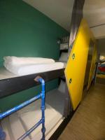 a dorm room with a bunk bed with a yellow door at Hive Bed and Backpacker蜂巢膠囊旅店 in Hualien City