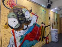 a wall with a painting of people on it at Hive Bed and Backpacker蜂巢膠囊旅店 in Hualien City