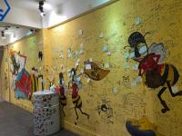 a wall covered in stickers and drawings on a wall at Hive Bed and Backpacker蜂巢膠囊旅店 in Hualien City