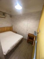 a small bedroom with a bed and a table at Hive Bed and Backpacker蜂巢膠囊旅店 in Hualien City