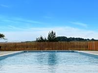 a swimming pool in front of a wooden fence at DOMAINE SAÂNE ET MER in Quiberville