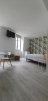a large white room with a bed and a chair at Agréable studio in Bourgueil