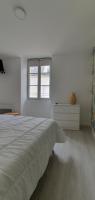 a white bedroom with a bed and a window at Agréable studio in Bourgueil