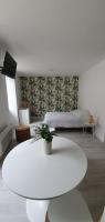 a living room with a white table and a bed at Agréable studio in Bourgueil