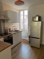 a kitchen with white cabinets and a white refrigerator at Clos Léonie - appartement 68m2 lumineux avec sauna in Givry