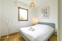 a bedroom with a white bed and a fan at Le Daubenton in Dijon