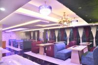 a restaurant with purple chairs and tables and a chandelier at City Square in Deoghar