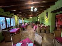 a restaurant with tables and chairs with pink tablecloths at Hotel De La Villa in Rubielos de Mora
