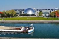 a boat in the water in front of a large building at Studio de charme in Pantin