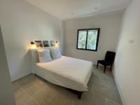 a bedroom with a bed with a window and a chair at Villa de standing in Calvi