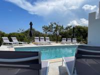 a swimming pool with lounge chairs and a bunch ofitures at Villa de standing in Calvi