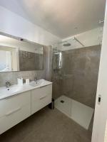 a bathroom with two sinks and a glass shower at Villa de standing in Calvi