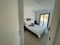 a bedroom with a bed in a white room at Villa de standing in Calvi