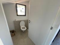 a small bathroom with a toilet with a window at Villa de standing in Calvi