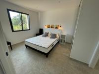 a bedroom with a white bed and a window at Villa de standing in Calvi