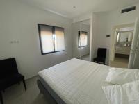 a bedroom with a white bed and two chairs at Villa de standing in Calvi