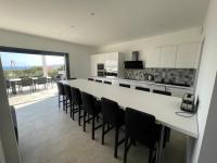 a kitchen with a large white counter and black chairs at Villa de standing in Calvi