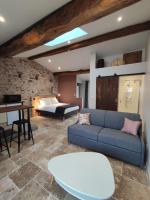 a living room with a couch and a bed at Studio 30m2 La Cave - Les Gîtes du Lac - Proche Nantes in La Chevrolière