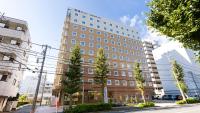 un gran edificio en una calle con árboles delante en Toyoko Inn Tokyo Keio-sen Higashi-fuchu-eki Kita-guchi, en Fuchu