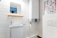 a white bathroom with a sink and a mirror at Renovated studio in the 6th district of Paris - Welkeys in Paris