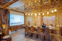 Una sala de conferencias con pantalla de proyección y paredes de madera. en Longji One Art Hotel, en Longsheng
