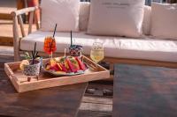 ein Tablett mit Obst auf einem Tisch mit Gläsern Wein in der Unterkunft Valerio Resort beach club in Margherita di Savoia