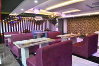 a dining room with purple chairs and tables at City Square in Deoghar