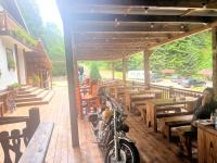 Una motocicleta estacionada en el porche de un restaurante. en Barlogul din Vidraru, en Curtea de Argeş