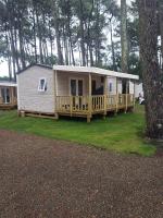 a tiny house with a porch and a deck at Mobil home 4&#47;6 personnes in Seignosse