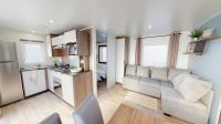 a small living room with a couch and a kitchen at Mobil home 4&#47;6 personnes in Seignosse