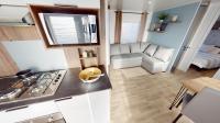 a kitchen and living room with a stove and a couch at Mobil home 4&#47;6 personnes in Seignosse