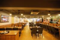 a restaurant with tables and chairs in a room at Hotel Dolphin Grand in Varanasi