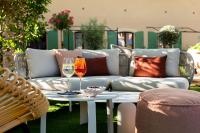 a patio with a couch and a table with wine glasses at La Bastide Bourrelly - Mathias Dandine in Cabriès