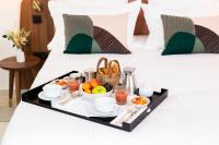 a tray of fruit and juice on a bed at La Bastide Bourrelly - Mathias Dandine in Cabriès