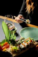 a woman sitting at a table with a plate of sushi at Academias Hotel, Autograph Collection in Athens