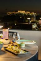 a table with plates of food with a view of a city at Academias Hotel, Autograph Collection in Athens