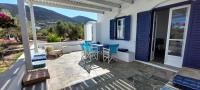 Un patio con una mesa y sillas en una casa. en Elisso Villas, en Platis Yialos Sifnos