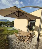 a wooden table and chairs under an umbrella at Maisonnette entre lac et Morgon in Pontis