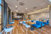 a restaurant with wooden tables and blue chairs at City Express Plus by Marriott Ensenada in Ensenada