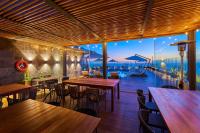 Un restaurante con mesas y sillas y vista al agua. en City Express Plus by Marriott Ensenada, en Ensenada