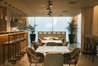 Un restaurante con mesas y sillas y un bar. en Howard Johnson Plaza La Ribera, en Resistencia