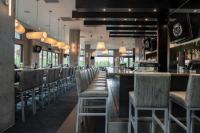 a bar with a row of chairs in a restaurant at Sutton Place Hotel Revelstoke Mountain Resort in Revelstoke