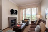 a living room with a couch and a fireplace at Sutton Place Hotel Revelstoke Mountain Resort in Revelstoke
