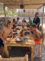 El KariaにあるAgafay, La Ferme Nomade Bivouacの木のテーブルの周りに座る人々