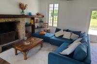 a living room with a blue couch and a fireplace at L&#39;Echappée d&#39;Aristide - proche Giverny &amp; 50 min Paris in Houlbec-Cocherel