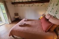 a bedroom with a large bed with pink sheets and pillows at L&#39;Echappée d&#39;Aristide - proche Giverny &amp; 50 min Paris in Houlbec-Cocherel