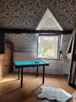 a ping pong table in a room with a window at L&#39;Echappée d&#39;Aristide - proche Giverny &amp; 50 min Paris in Houlbec-Cocherel