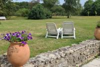 two chairs and a table in a yard with flowers at L&#39;Echappée d&#39;Aristide - proche Giverny &amp; 50 min Paris in Houlbec-Cocherel
