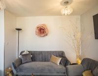 a living room with a couch and a flower on the wall at Le Flamboyant - Confort &amp; Rareté - Premium in Saint-André-les-Vergers